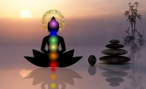 illustration of chakra colors imposed on meditating silhouette