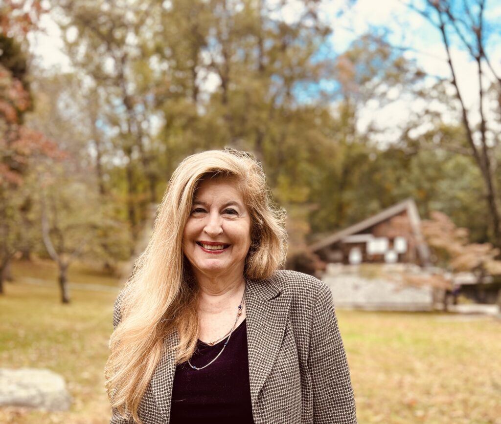 smiling woman, Miriam Belov with Nakashima compound grounds in the background