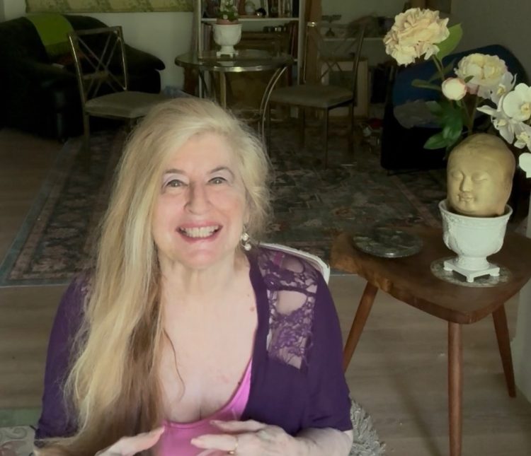 Miriam Belov in purple dress smiling at the camera